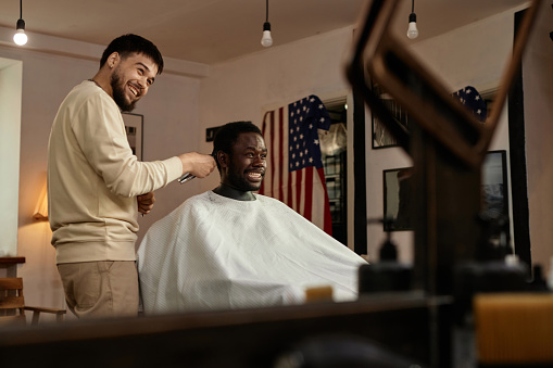 African American happy man cutting his hair in barber shop