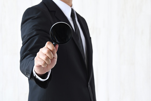Business man analyzing with magnifying glass