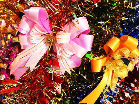 Venetian 'plague doctor' mask with trumpet confetti and streamers around against a pink background.