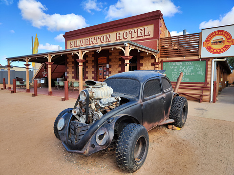 Pimped-up, pitch-black Volkswagen beetle, a homage to Mad Max’s V8 Interceptor, parked in front of the historical Silverton Hotel in Silverton, a small village at the far west of New South Wales, Australia. The town is often referred to as a ghost town, however, there remains a small permanent population and is a film set and popular tourist destination in the area.