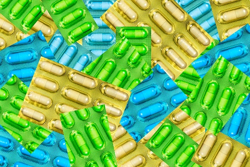 An array of pills arranged in a neat line on a flat surface