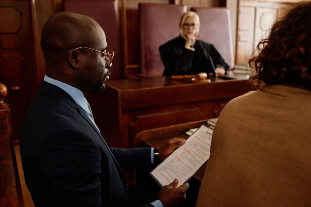 istock Focus on young confident attorney reading juridical document in court 1746068598