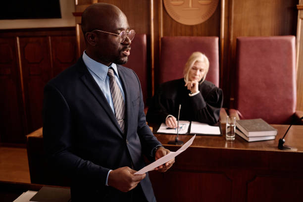 istock Young confident lawyer with juridical document defending suspect 1746069779