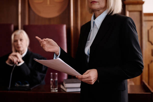 istock Female prosecutor with document standing in front of suspect and attorney 1746070307