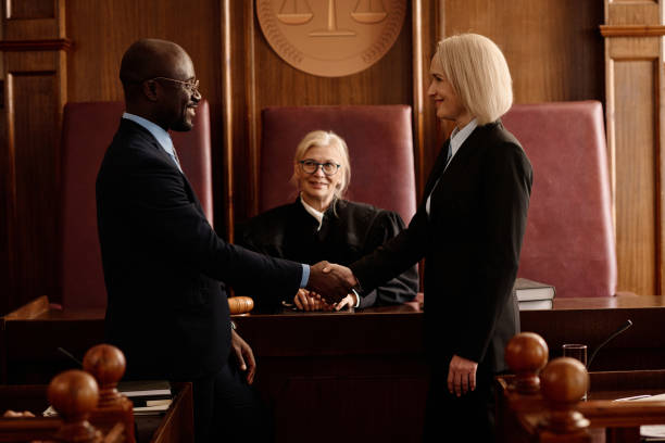 istock Side view of happy prosecutor and attorney shaking hands after making agreement 1746071566