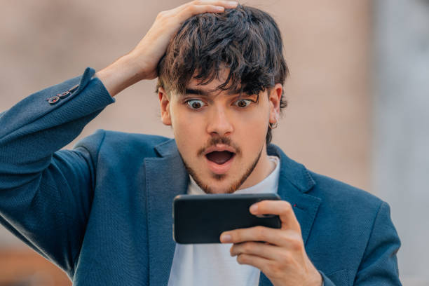 istock young male with mobile phone and surprised face 1746096101