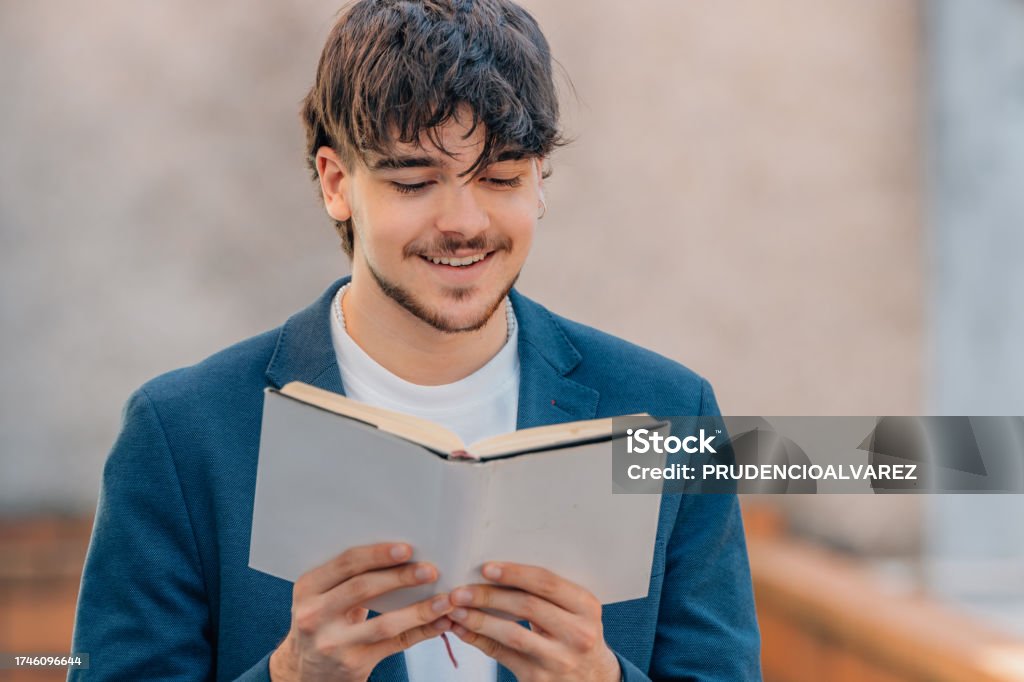 Student Using Textbook Student With Textbook Reading On The Street Stock Photo - Download ...