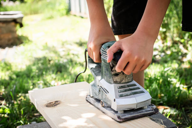 istock Woodworker planes a board with an electric planer 1746097727