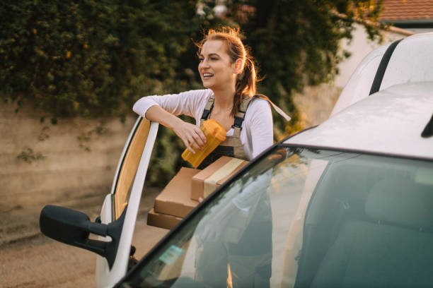 istock Woman with a reusable water bottle delivering packages in a white van 1746105573