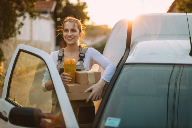 istock Woman with a reusable water bottle delivering packages in a white van 1746105582