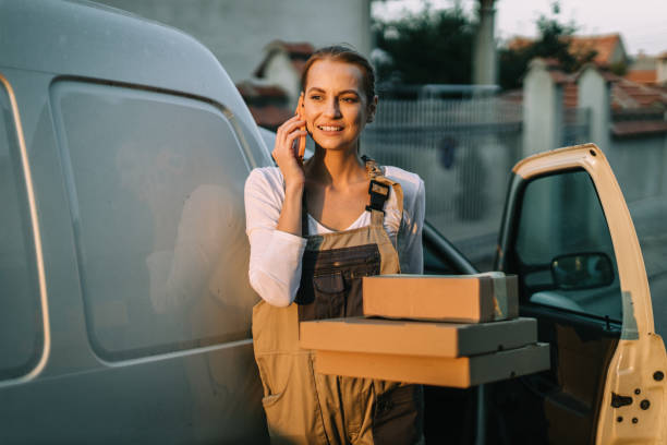 istock Woman talking on a phone and delivering packages in a white van 1746107229