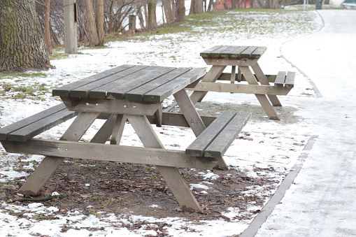 Empty benches and tables in the park in winter