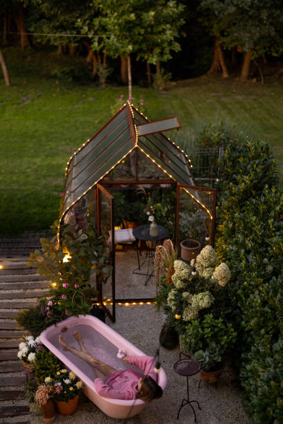 istock Cozy backyard with a woman bathing in pink bathtub 1746114841