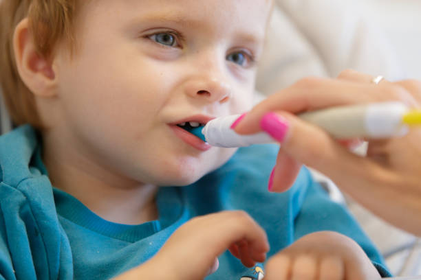 istock Blond toddler biting on designed spoon at feeding therapy and smiling 1746115983
