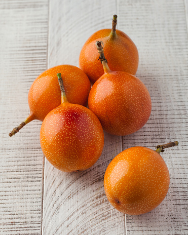 Ripe juicy tomarillo on a white wooden background. The concept of fruit harvesting