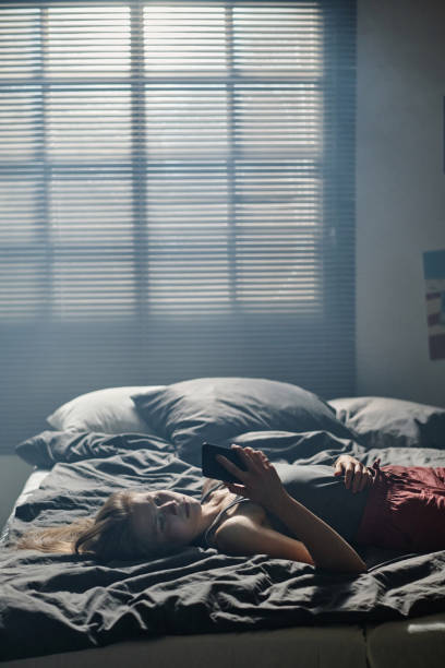 istock Stressed girl suffering from cyberbullying while lying on bed against window 1746125584