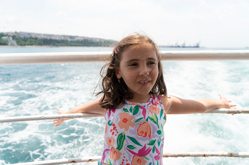 Little girl is on a ship, boat or ferry.