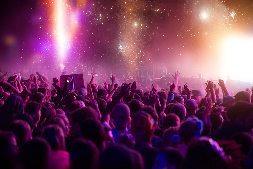 Shot of a large crowd at nightclub,  enjoying a music, with stage lights