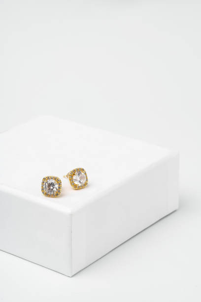 istock Golden earrings on display on white background 1746140890