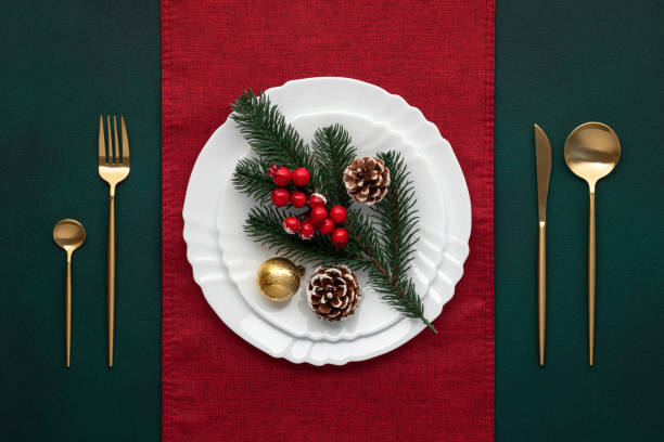 istock Festive table setting, christmas decoration. Dishware, golden cutlery. Celebration xmas eve: exquisite arrangement, red accent. Gold bauble, fir cones, evergreen tree. Holiday banquet, view from above 1746142643