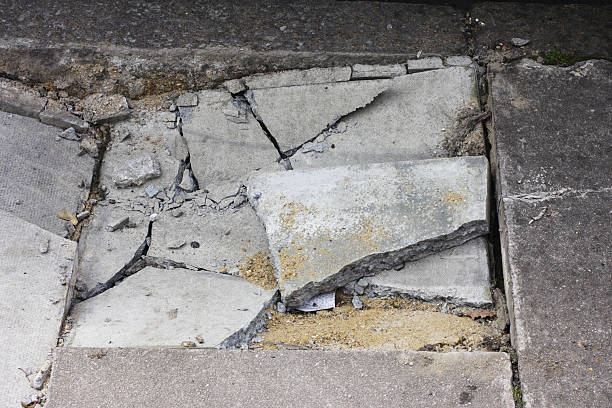 istock Broken pavement sidewalk damage cracked paving stones next to kerb 174614405