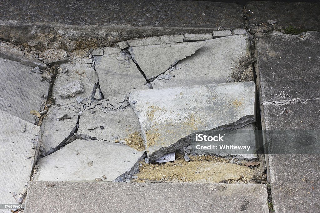 Broken pavement sidewalk damage cracked paving stones next to kerb Damage to a London pavement next to the kerb. Broken paving stones in jigsaw pieces. Architecture Stock Photo