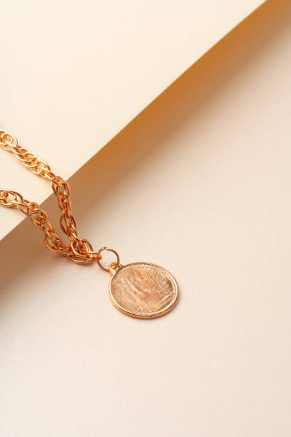 istock Golden chain with pendant on paper background close up 1746144864