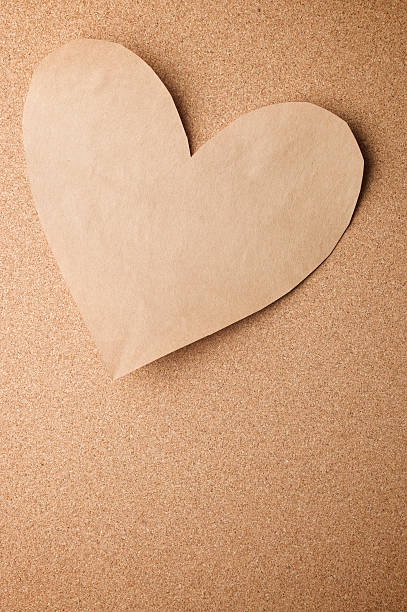 istock Recycled Plain Brown Paper Heart on Natural Cork Board 174614497