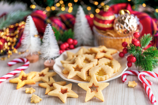 Christmas home made stained glass cookies on white background with bokeh lights, selective focus