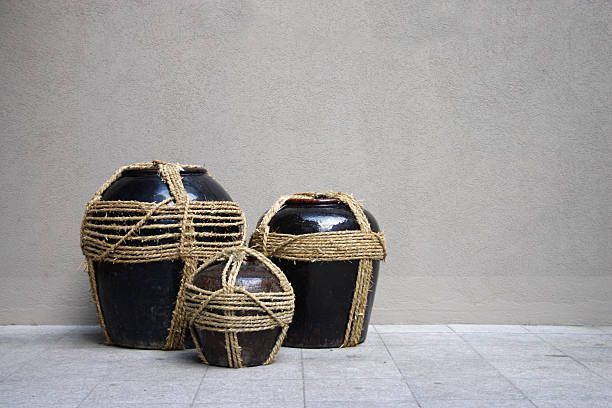 Clay jars of ethnic inspiration against plain wall; can be used as travel background.