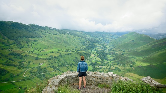 A woman looks at the valley from a viewpoint in the Portillo de Lunada mountain pass in Cantabria, Spain
