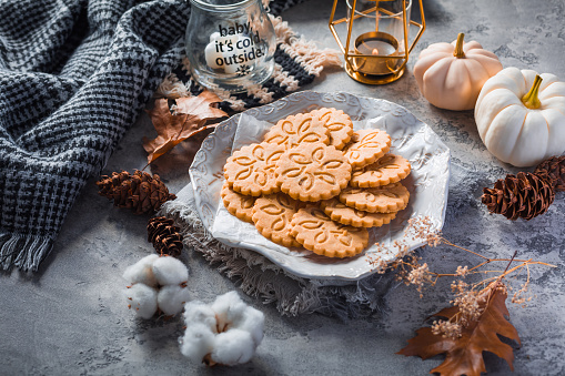 Chai latte cookies or ginger biscuits with pumpkins and candles for autumn season