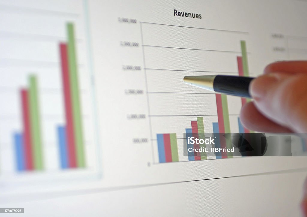 A bar graph showing an increase in revenue a businessman reviewing a chart Revenue Stock Photo