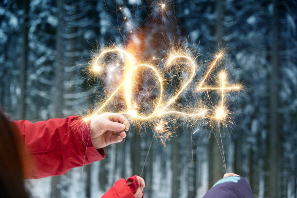 mãos escrevendo 2024 com espumantes - festa de ano novo - sparkler sparks new years eve human hand - fotografias e filmes do acervo