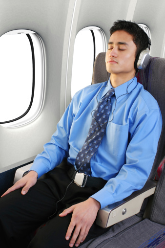 Businessman sleeping on an airplane flight.