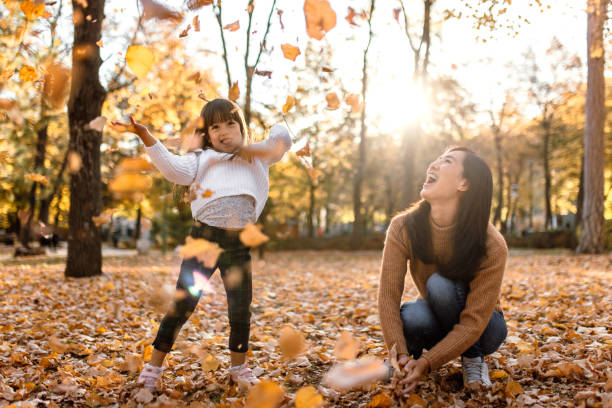 istock Mother and daughter having fun playing with autumn leaves 1746184867