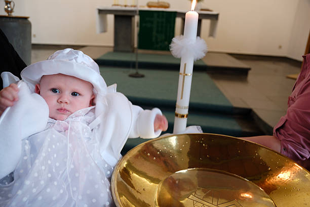 right after christening, baby beside font, special candle hold by godmother