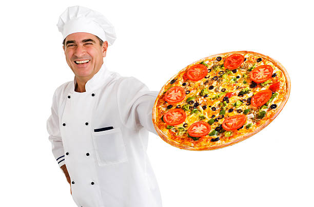 Smiling chef holding vegetable topped pizza stock photo