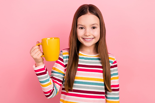 Photo of happiness cheerful little girl hold cup sweet hot chocolate cafeteria relax favorite beverage isolated on pink color background.