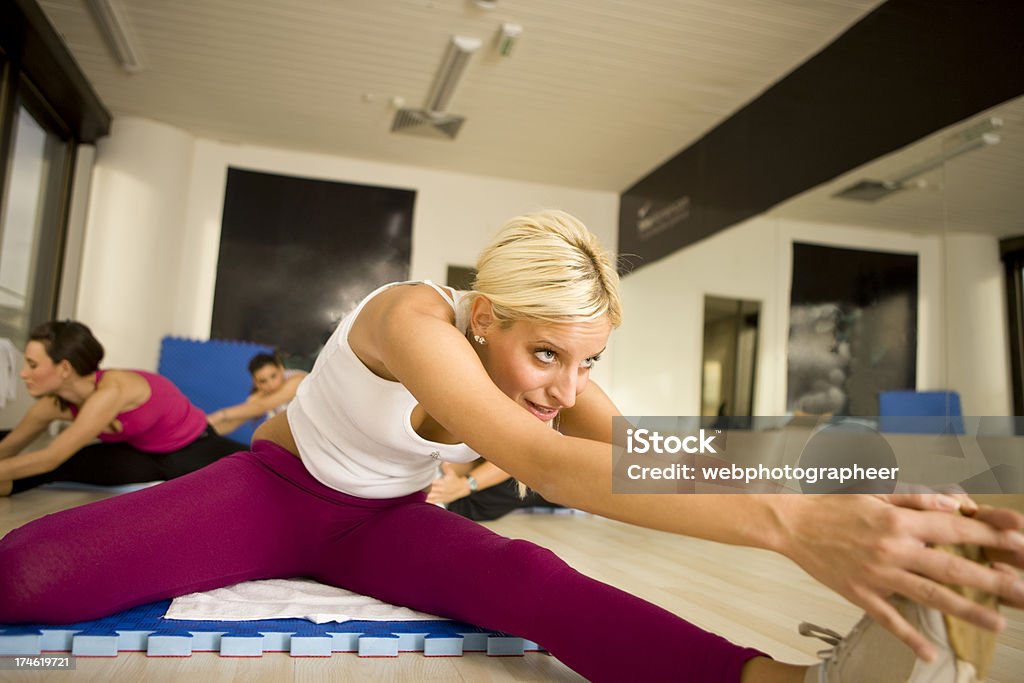 Donne lo stretching sul Materassino ginnico - Foto stock royalty-free di Abbigliamento sportivo