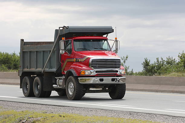 Red Dump Truck Travelling On Highway To A Construction Site stock photo