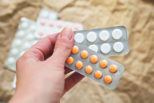 istock he pills blisters in woman's hand against blurred craft paper 1746201680