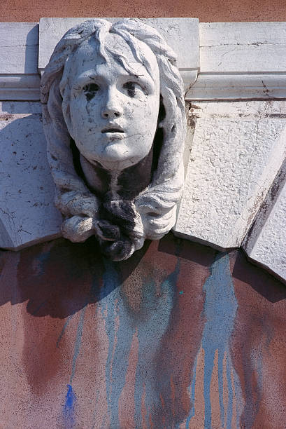 A sculptured keystone above a blind arch on a building in Venice, Italy.