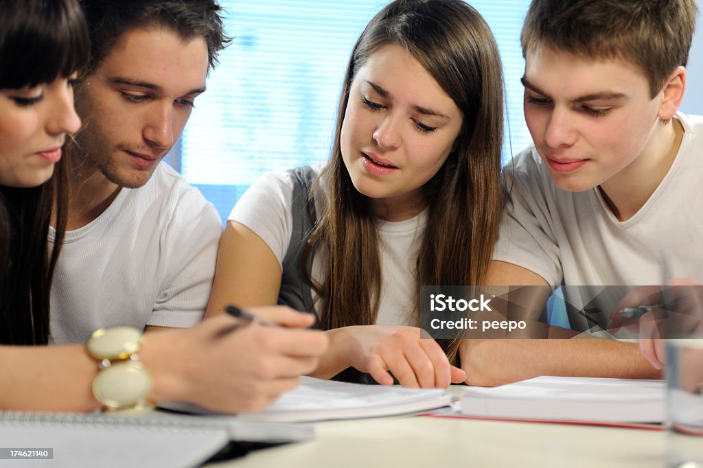 Estudiantes trabajan juntos en una asignación - Foto de stock de Adolescencia libre de derechos