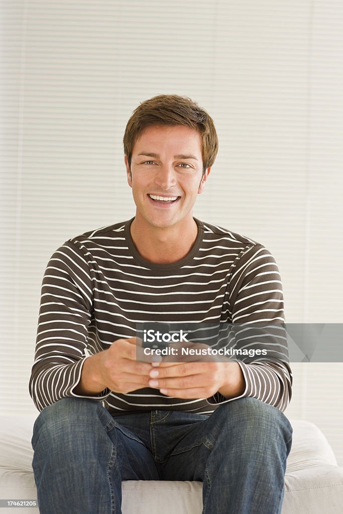 Élégant jeune homme à l'aide de téléphone portable sur fond blanc - Photo de 20-24 ans libre de droits
