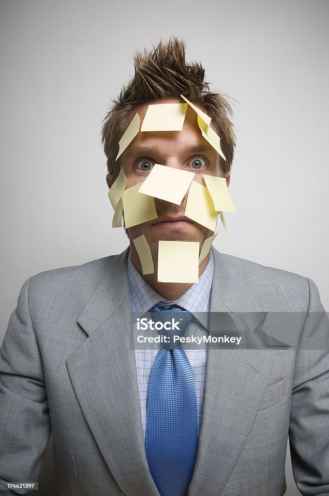 Uomo d'affari faccia coperto in giallo Sticky note guardando fotocamera - Foto stock royalty-free di Stress emotivo