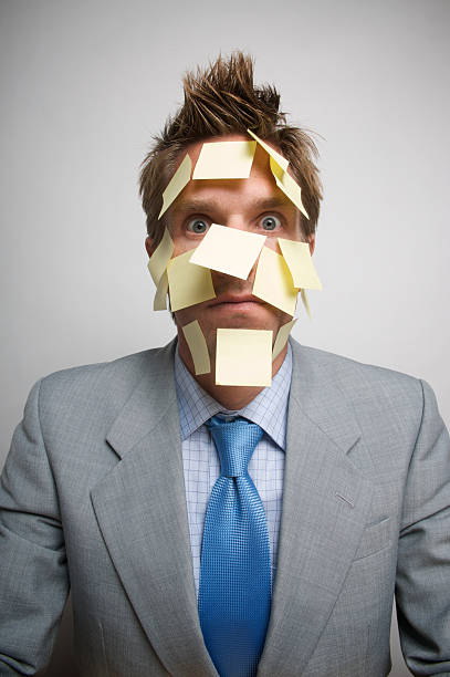 istock Businessman Face Covered in Yellow Sticky Notes Looking at Camera 174621397