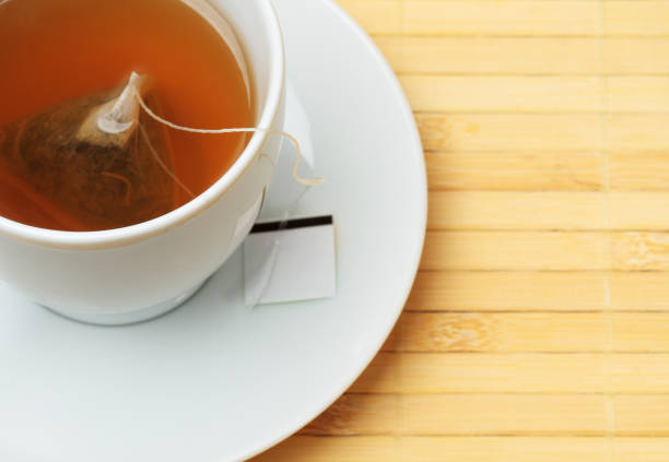 istock White tea cup with steeping tea bag on a light wooden table 174621579