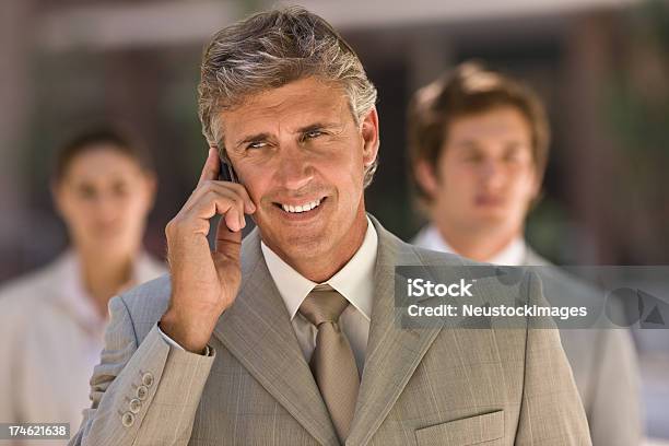 笑顔携帯電話で話している成熟したビジネスマン - 3人のストックフォトや画像を多数ご用意 - 3人, 50-54歳, オフショット
