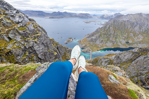 Female hikes in the mountains of Northern Norway, she looks at the view, autumn